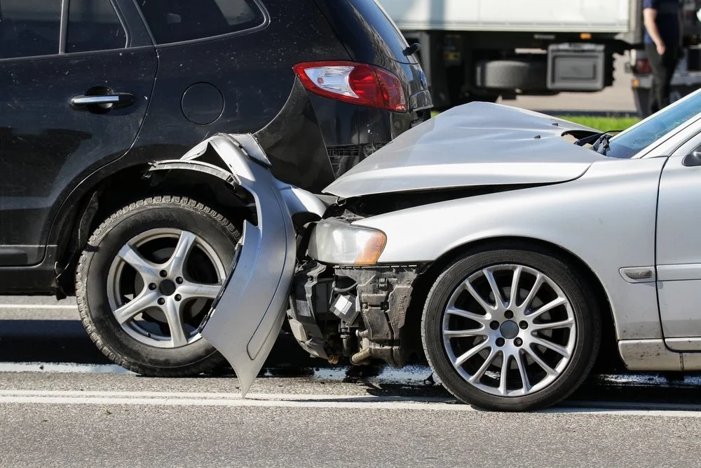 Car accident scene with damaged vehicles on the roadway, illustrating The Dixon Impact-to-Recovery Protocol and how it helps protect injury claims.