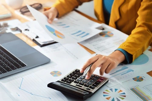 An image showing a calculator and documents representing the valuation of a workers' compensation case.