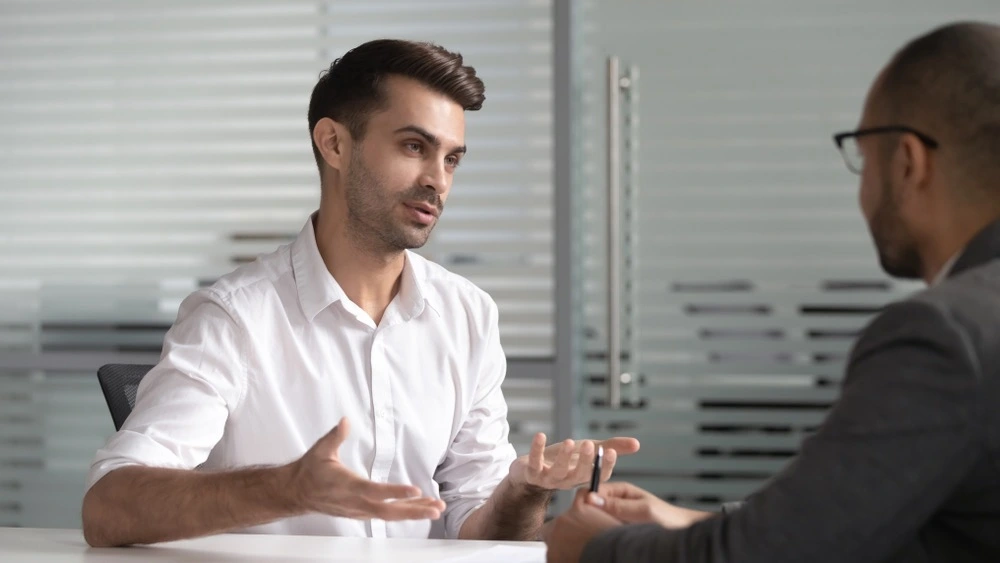 An image of a person talking to an insurance agent, representing the process of dealing with insurance companies after a car accident.