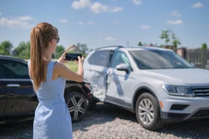 Snapshot of a person taking photos at a crash scene, representing the crucial steps to take immediately after a car accident.