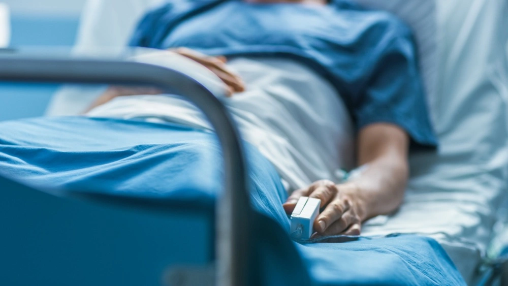 Image of a person in a hospital bed, illustrating common injuries from texting and driving accidents.