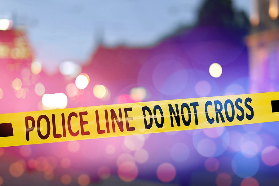 Snapshot of police cars with flashing lights and crime scene tape, symbolizing the serious nature of stop sign accidents in St. Louis.