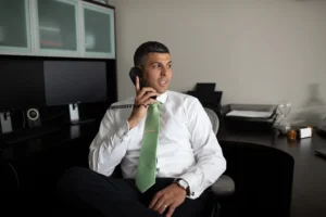 Chris Dixon speaking on the phone in his office, encouraging clients to contact a St. Louis personal injury lawyer at The Dixon Injury Firm.