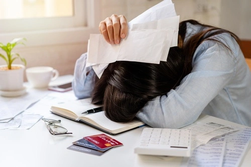 Snapshot of a stressed person surrounded by bills, illustrating the economic damages often involved in personal injury cases.