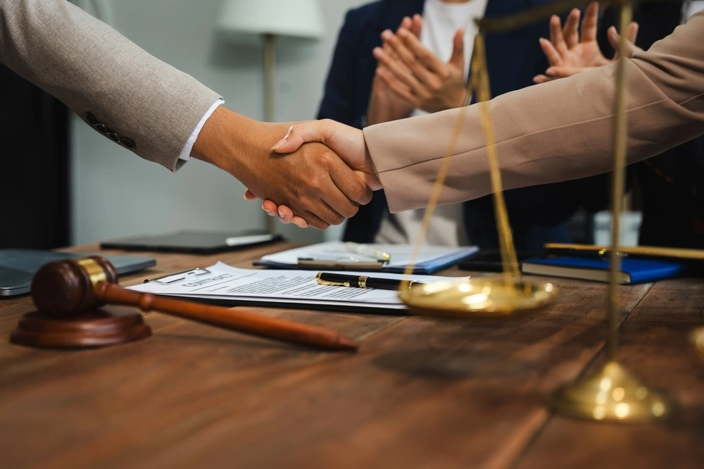 Client shaking hands with a St. Louis medical malpractice lawyer in an office, illustrating The Dixon Injury Firm’s commitment to supporting and advocating for clients.